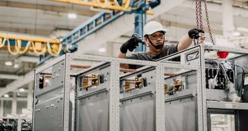 Technicians assembling power converter cabinets on the factory floor